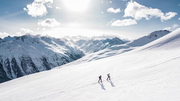 two walkers climbing a mountain in the snow